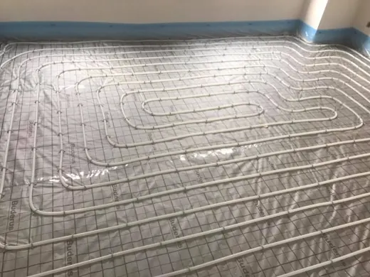 Pose d’un chauffage par le sol : tubes fixés sur panneaux isolants