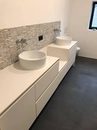 Salle de bain avec meuble double vasque blanc et robinetterie murale